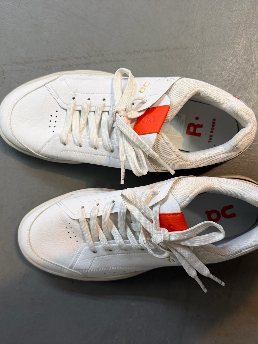 On Running Women’s White Leather Sneakers with Orange Tongue Accent